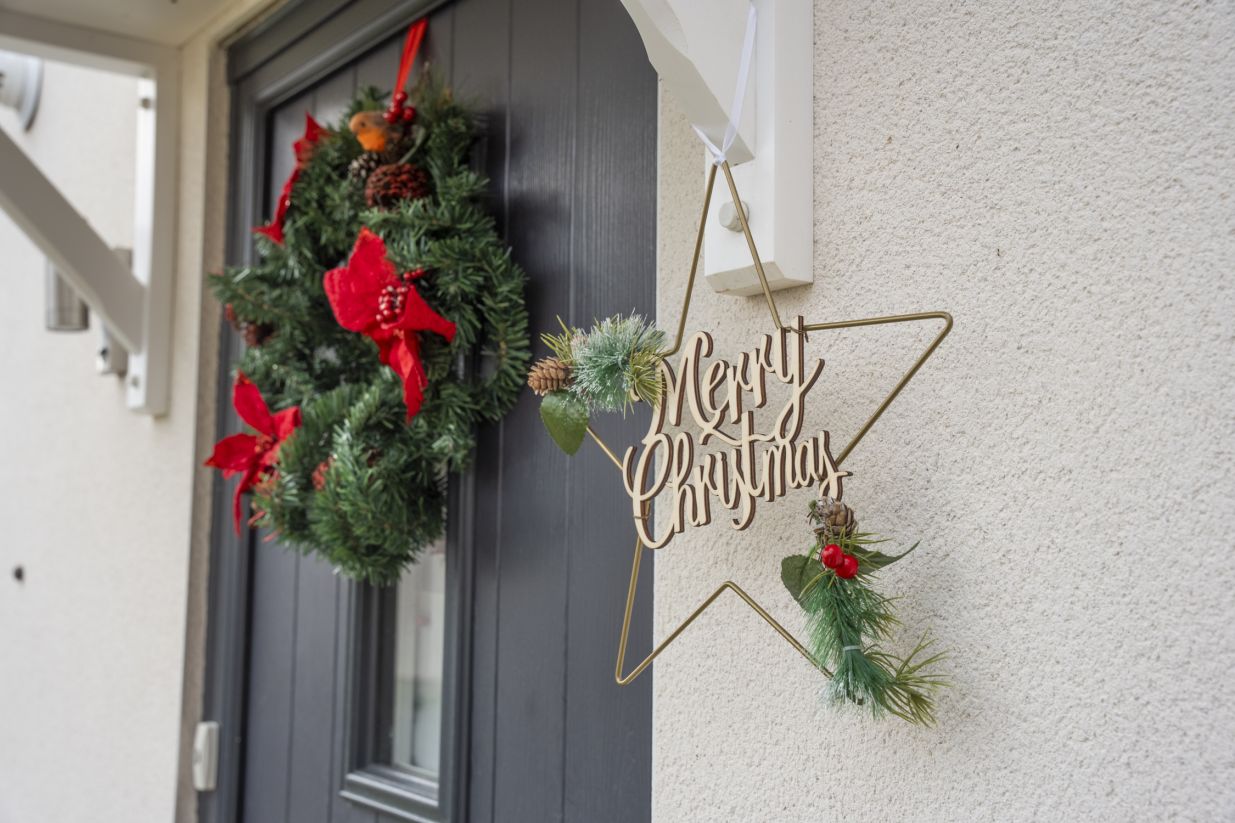 A Christmas wreath on the door of one of our homes with a Merry Christmas star sign.