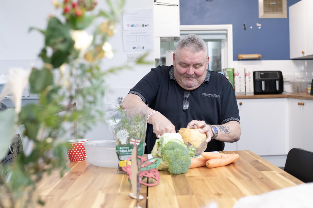 Image of Mark, a veteran and LiveWest resident, chopping vegetables.