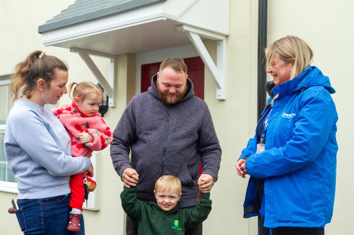 A family of four talking to a LiveWest colleague.