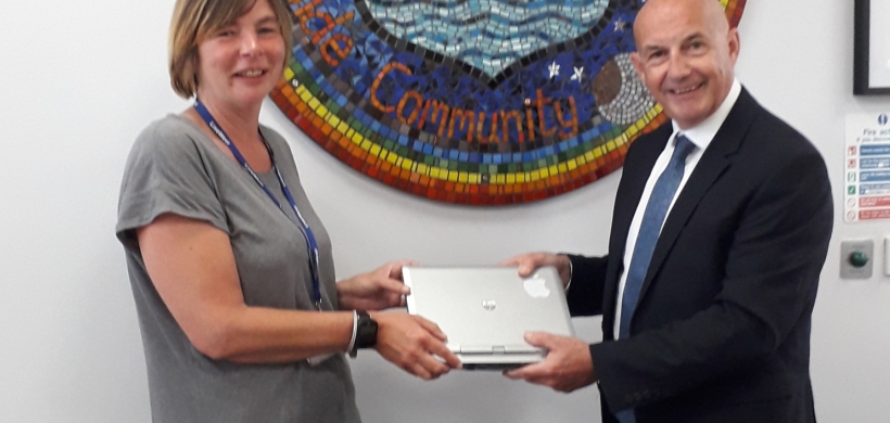Justine a Community Connector handing over a laptop 