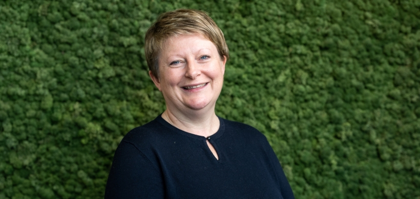 Glynnis smiling with a green leafy background