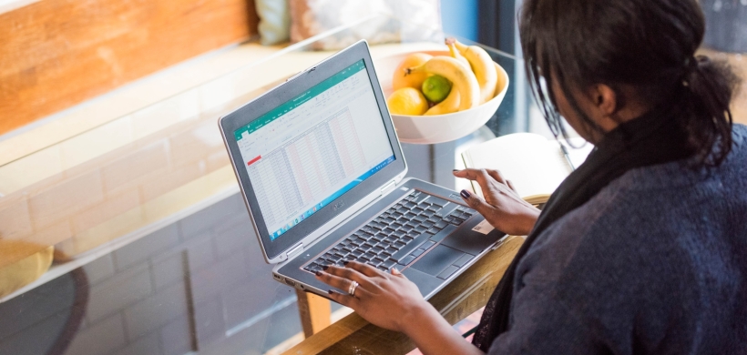 Someone using a laptop sat at a table. 