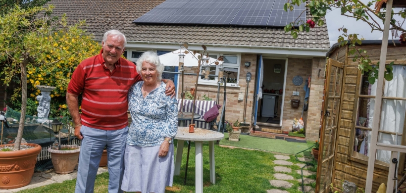 Our customers, James and Catherine, stood in their garden outside their bungalow.