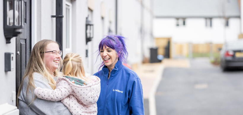 Image of a LiveWest colleague laughing with a LiveWest customer and her daughter.