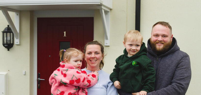 Caitlin and Chris with their son and daughter smiling at the development.