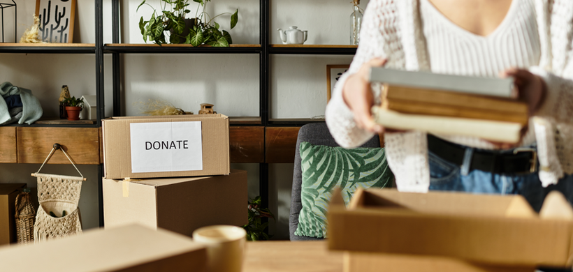 Woman decluttering home with donate box