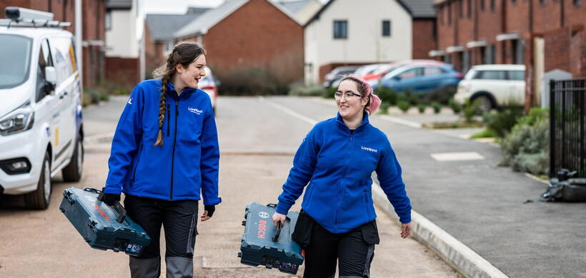 LiveWest colleagues carrying toolboxes on a street. 