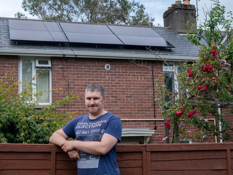 Robert stood outside his home with solar panels.