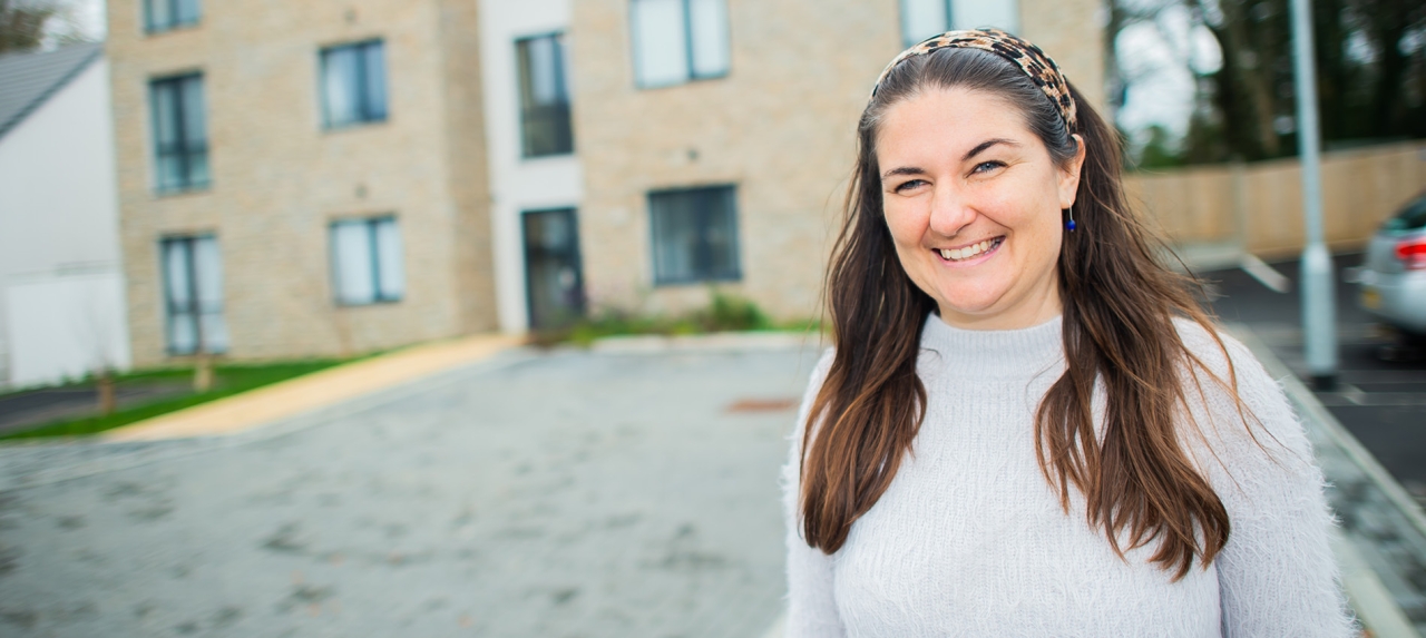 A woman standing in front of a building.