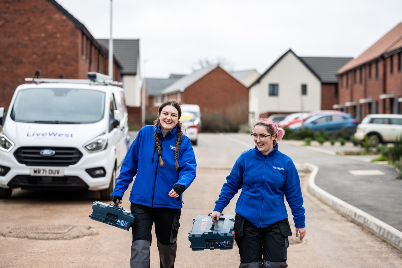 LiveWest colleagues walking along a road with toolboxes.