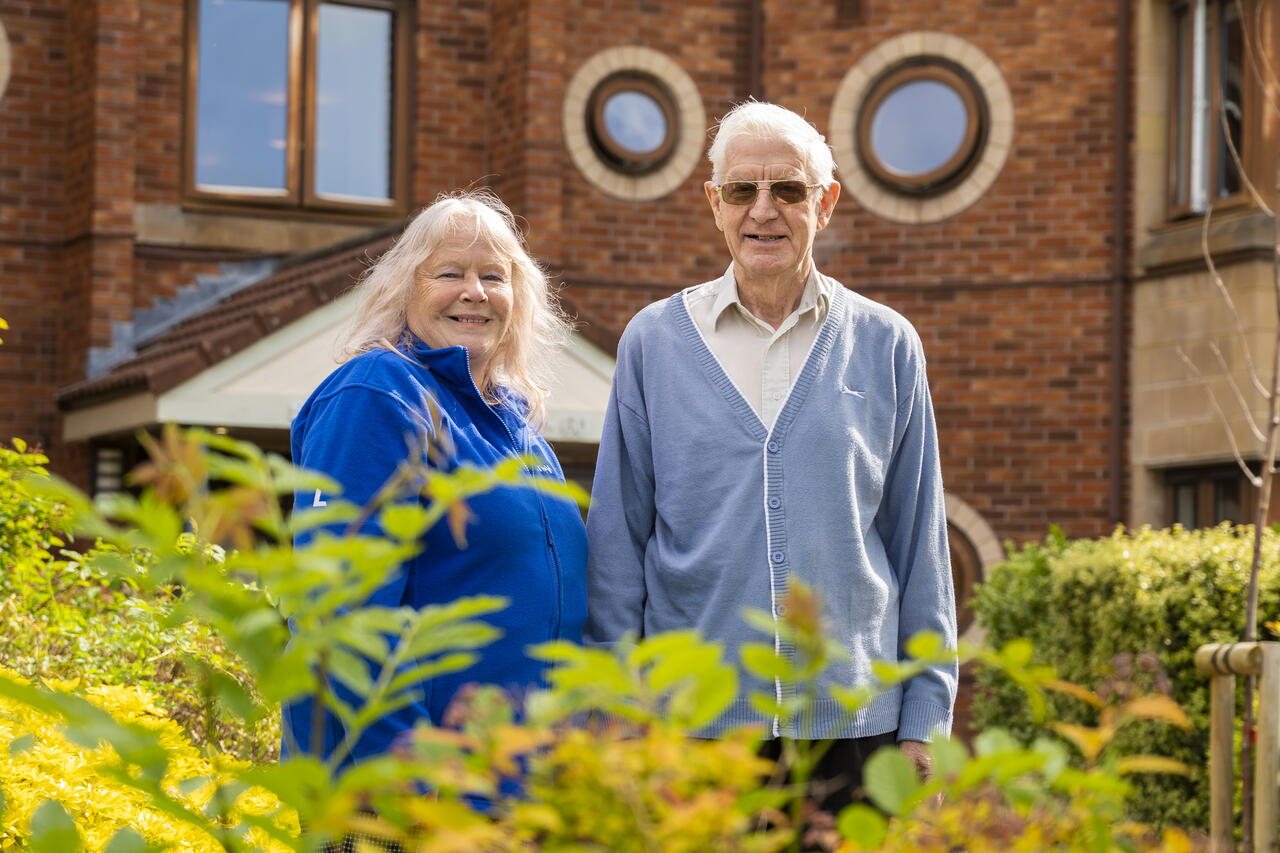Image of a LiveWest colleague and customer stood outside in a garden smiling.