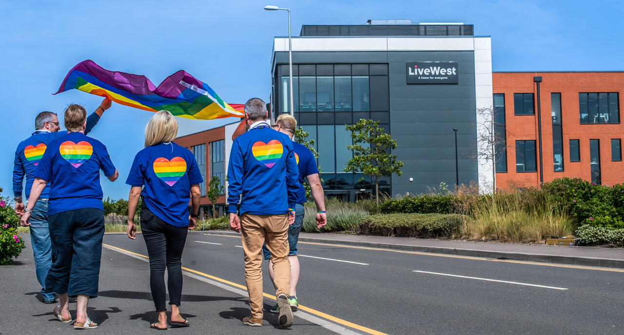 Image of LiveWest colleagues walking towards our office, wearing LGBTQIA+ flags on their backs.
