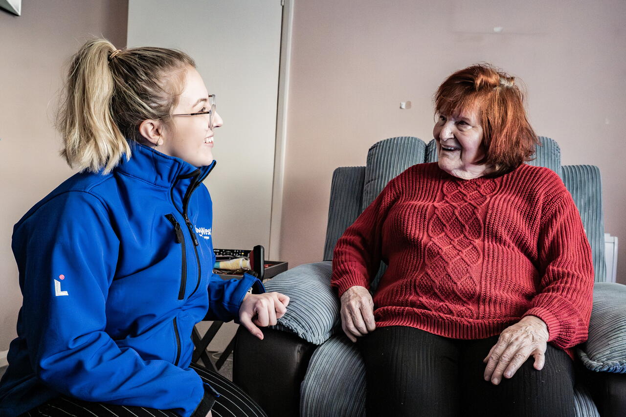 Image of a LiveWest colleague speaking and smiling with a customer in their home.