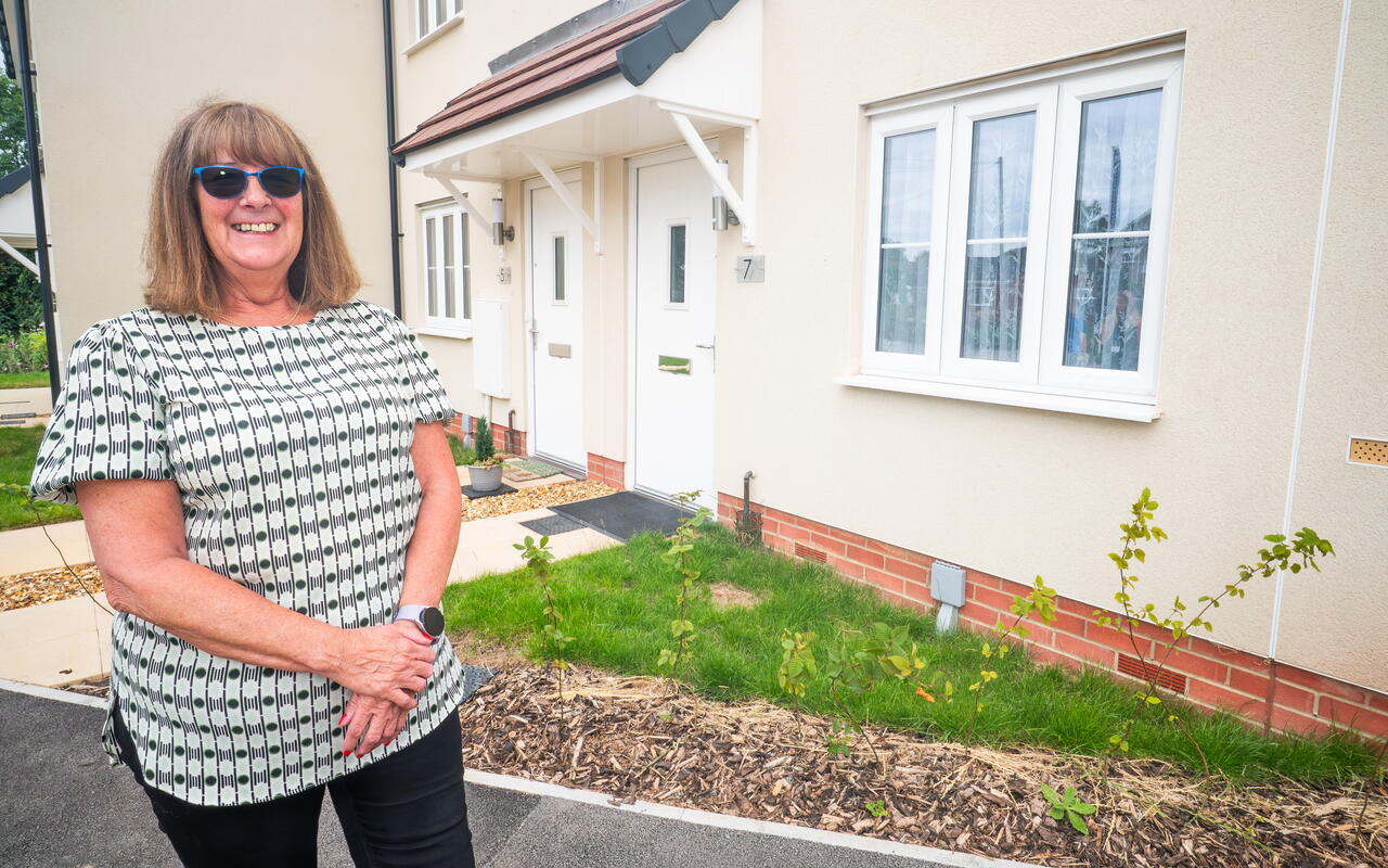 Karen smiling in front of her new rural home
