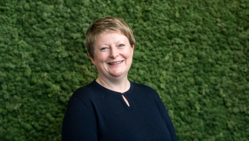 Glynnis smiling with a green leafy background