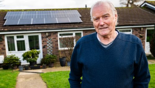 LiveWest resident Patrick outside his home with solar panels on the roof.