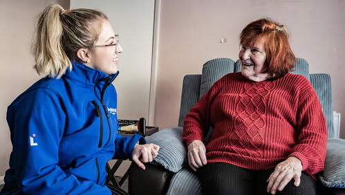 Image of a LiveWest colleague speaking and smiling with a customer in their home.
