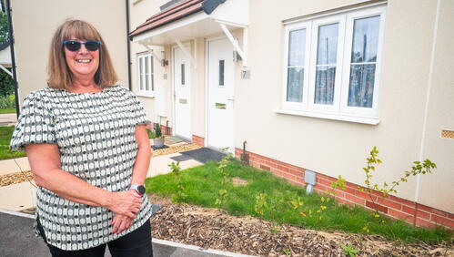 Karen smiling in front of her new rural home